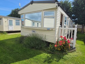 A mobile home with a porch, a window, and a door. - Seaside Haven Retreat in Skegness (Skegness)