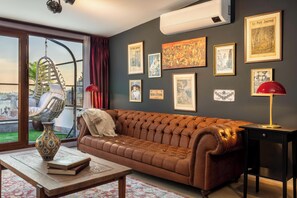 A living room with a brown leather sofa, a hanging chair, a wooden coffee table, and a red lamp. - Panoramic Bosphorus View Terrace At Monnas Suite (Istanbul)