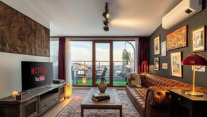 A living room with a television, sofa, coffee table, and artwork on the walls. - Panoramic Bosphorus View Terrace At Monnas Suite (Istanbul)