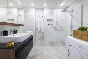 A modern bathroom with a large mirror, a sink, a shower, and a washing machine. - Panoramic Bosphorus View Terrace At Monnas Suite (Istanbul)