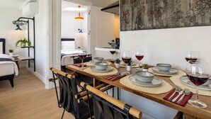 A dining area with a long table set for four, chairs, and wine glasses. - Huge Balcony Taksim Rooftop Apt At Monnas Suite (Istanbul)