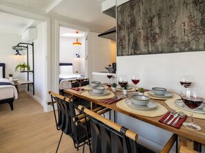 A dining area with a long table set for four, chairs, and wine glasses. - Huge Balcony Taksim Rooftop Apt At Monnas Suite (Istanbul)