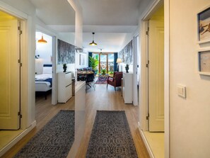 Ein Hotelzimmer mit Bett, Schreibtisch, Stuhl, Esstisch und Blick auf die Stadt.