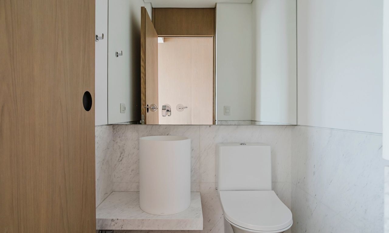 A bathroom with a toilet, a sink, and a mirror.