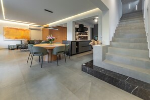 Ein modernes Interieur mit Essbereich, Küche und Treppe.