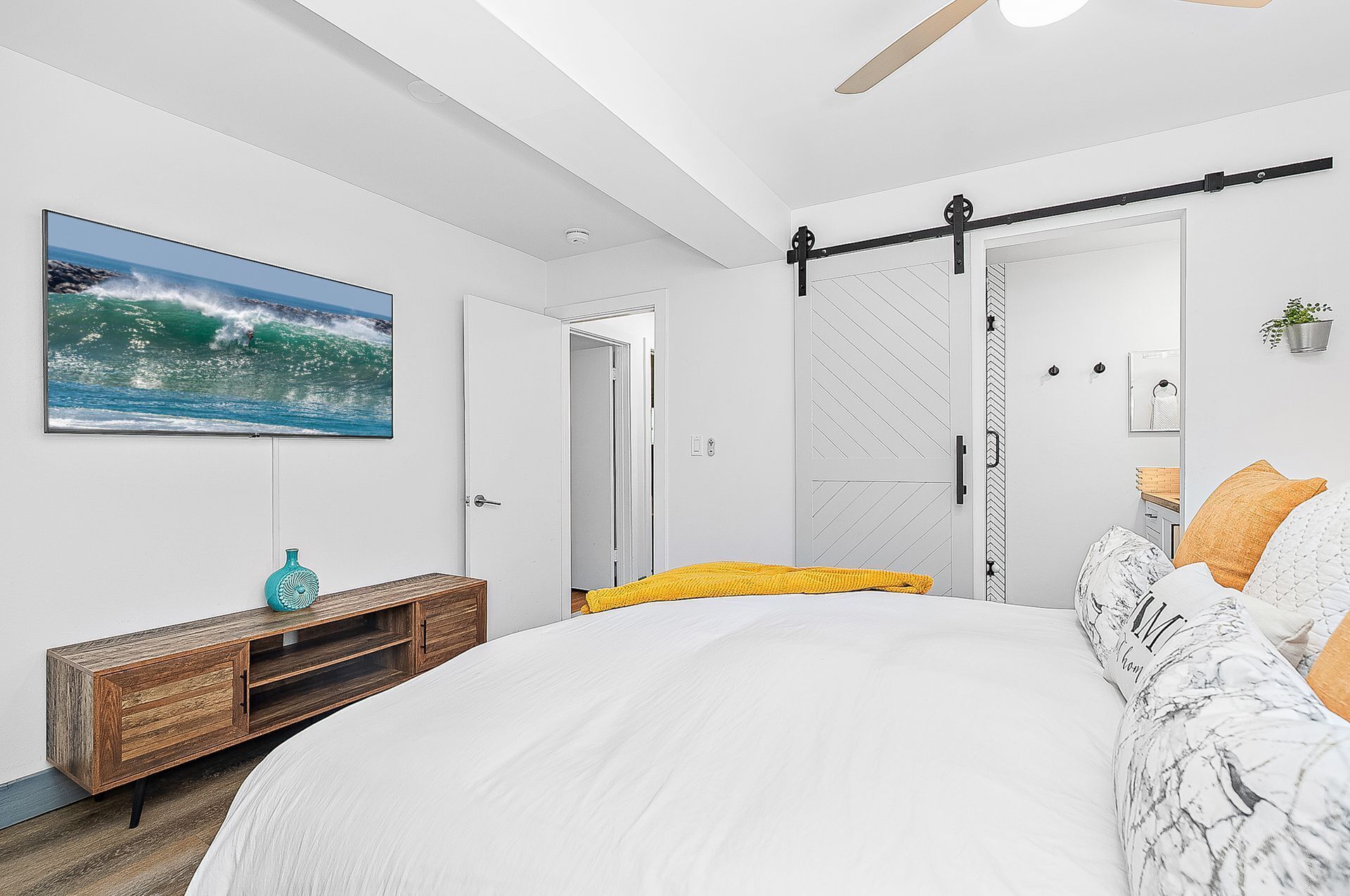 Ein Schlafzimmer mit einem Bett, einem Fernseher, einer Schiebetür und einem Holzkasten.