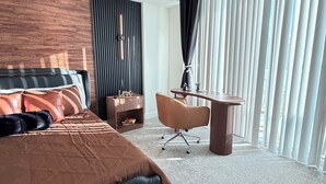 Et moderne hotelværelse med en stor seng, et skrivebord og en stol.