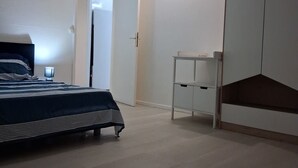 Una camera da letto con un letto, un armadio, una scrivania e una ventola a soffitto.