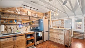 A kitchen with wooden cabinetry, a built-in oven, and a refrigerator. - 3-BR Waterfront, Sebastian Inlet Views, Private Dock & Daily Wildlife Sightings (Micco)