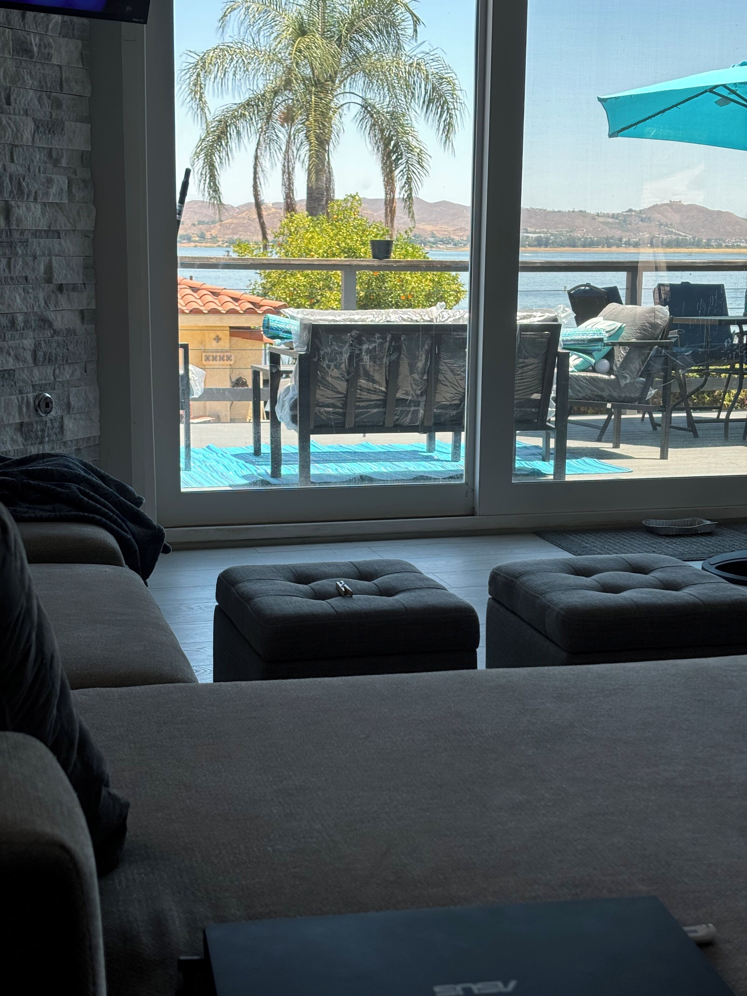 A living room with a large window overlooking a pool area.