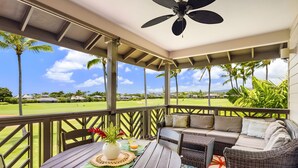 A covered outdoor seating area with a table, chairs, and a ceiling fan. - Ocean View 6BR, 2 Condos for 16 in Koloa! (Koloa)