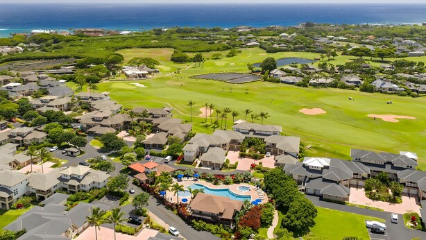 A golf course with a swimming pool and residential buildings. - Ocean View 6BR, 2 Condos for 16 in Koloa! (Koloa)
