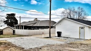 Un quartier résidentiel avec des maisons, un garage et un abri de jardin blanc.
