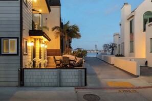 Un edificio moderno con balcón, mobiliario exterior y vistas al agua.