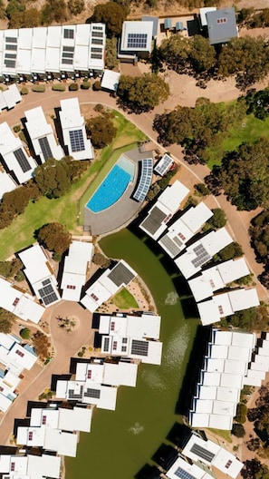 A residential area with multiple houses arranged around a central water feature.