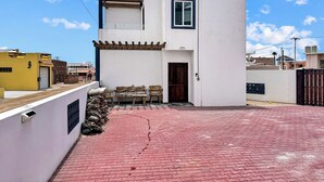 Un bâtiment à deux étages, doté d’un toit plat, d’une petite fenêtre et d’une porte.