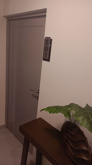 Eine Tür mit einem Hinweisschild, eine Bank und ein Blumentopf.