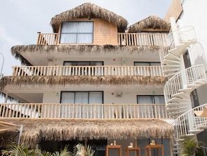 Un hotel de varios pisos con techos de paja y una escalera en espiral.