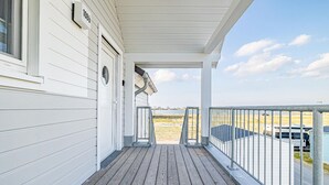 A white building with a covered porch, a view of the beach, and a parked RV. - Stunning apartment in Kappeln with sauna (Kappeln)