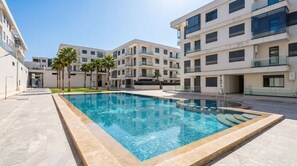 A modern building with a swimming pool, palm trees, and a clear sky. - Luxury apartment, Agadir bay, pool&fibre (Agadir)