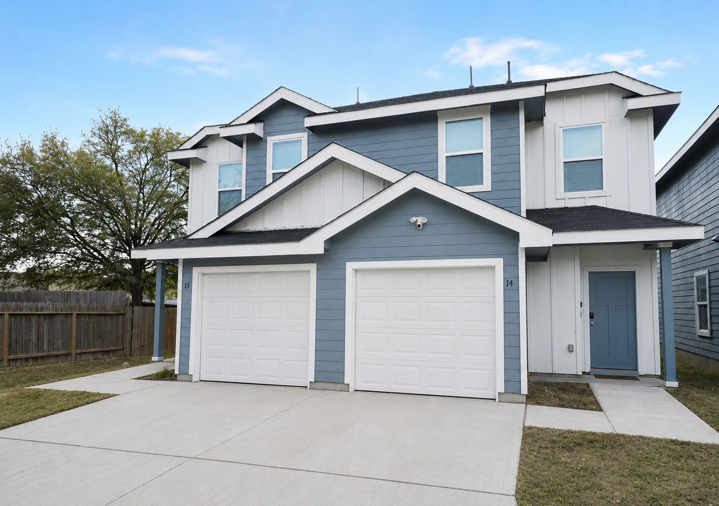 A two-story house with a garage, a front door, and a small porch.