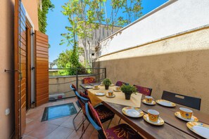 An outdoor dining area with a table set for four, chairs, and a potted plant. - Casa Rossa, Vrsar, Croatia (Vrsar)