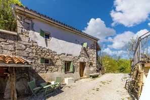 A rustic stone building with a gravel courtyard, outdoor seating, and a clear blue sky. - Nature & Pool Escape - Stone House, Zvoneća, Croatia (Zvoneća)