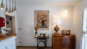 Une pièce comprenant une machine à coudre, une lampe, une radio et un tableau accroché au mur.
