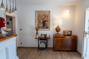 Une pièce comprenant une machine à coudre, une lampe, une radio et un tableau accroché au mur.
