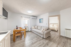 A modern apartment with a dining area, a sofa, and a bed. - Lovrinovi Retreat - Apartment 1, Zvoneća, Croatia (Zvoneća)