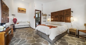 A bedroom with a stone floor, wooden bed frame, bedside tables, and a wardrobe. - HOTEL CUADRA CASONA EL CALVARIO (Huichapan)