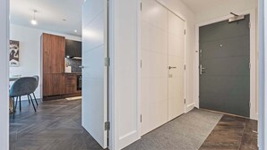 Een modern interieur met een gang die leidt naar een eetgedeelte en een donkere kamer.