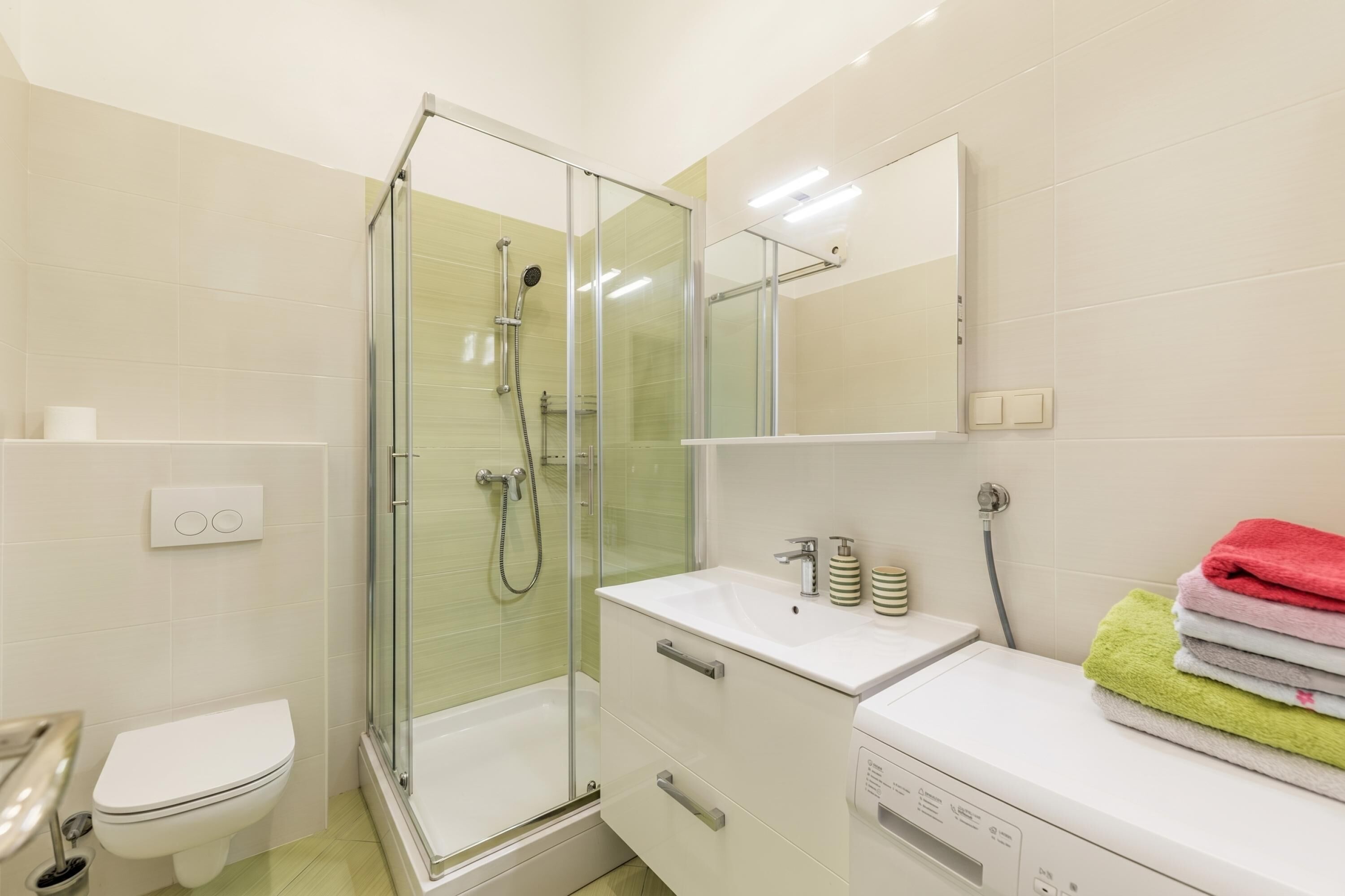 Ein Badezimmer mit einer Duschkabine, einem weißen Waschbecken und einer Toilette.