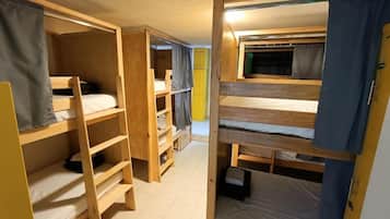 A room with bunk beds, a window, and a door.