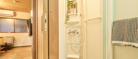 A modern bathroom with a shower, a towel rack, and a sink.