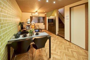 Ett kompakt bostadsutrymme med en matplats, en tv och en trappa.