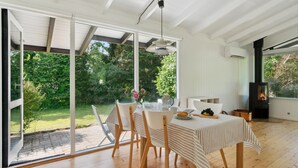 A dining area with a table set for four, large windows, and a fireplace. - Lovely home in Vejby with WiFi (Vejby)