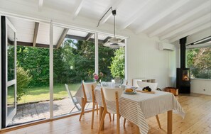 A dining area with a table set for four, large windows, and a fireplace. - Lovely home in Vejby with WiFi (Vejby)