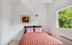 A bedroom with a bed, a window with a view of greenery, a painting on the wall, and a hanging light fixture. - Lovely home in Vejby with WiFi (Vejby)