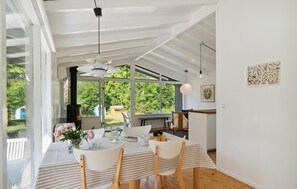 A dining area with a table, chairs, a hanging light fixture, and a view of the outdoors. - Lovely home in Vejby with WiFi (Vejby)