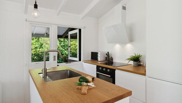 A modern kitchen with a wooden countertop, stainless steel sink, and a microwave. - Lovely home in Vejby with WiFi (Vejby)