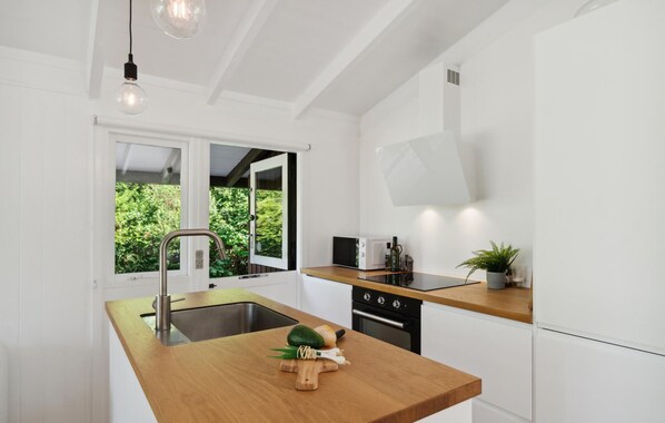 A modern kitchen with a wooden countertop, stainless steel sink, and a microwave. - Lovely home in Vejby with WiFi (Vejby)