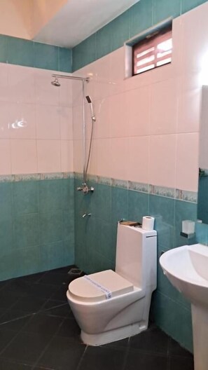 Habitación familiar, balcón, vistas al jardín | Baño | Ducha, artículos de higiene personal gratuitos y papel higiénico