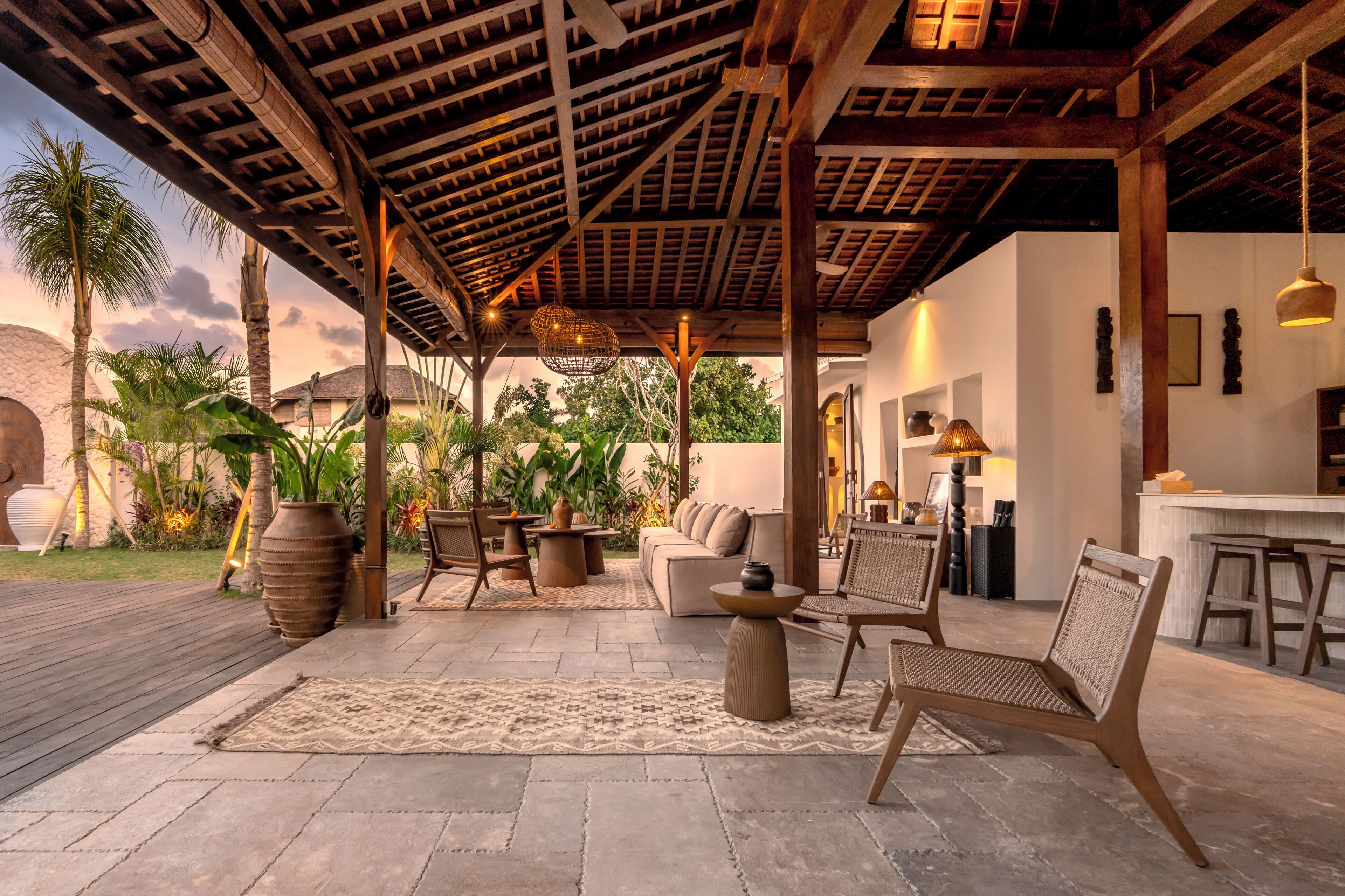An outdoor patio with a wooden ceiling, seating area, and a bar.