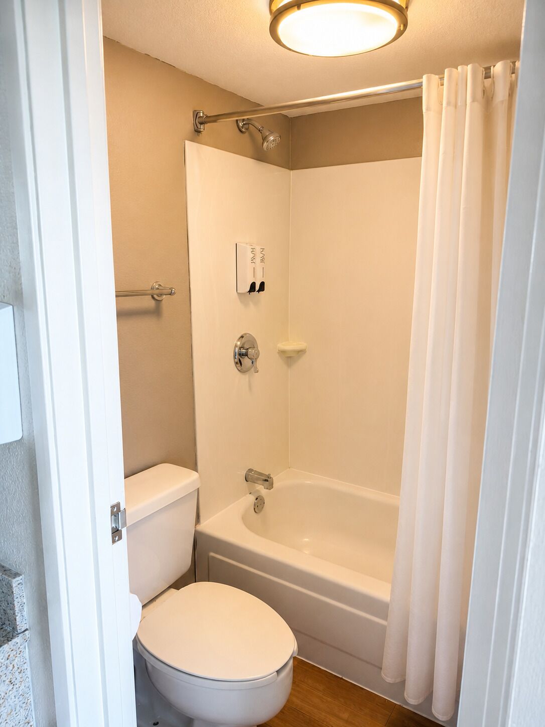 A bathroom with a toilet, a bathtub, and a shower curtain.