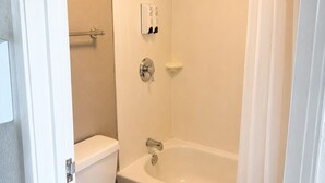 A bathroom with a toilet, a bathtub, and a shower curtain. - Cranberry Park Hotel (Cranberry Township)