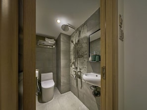 Un baño moderno con inodoro, lavamanos y ducha.