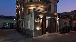 A multi-story hotel with a prominent entrance, balconies, and a well-lit facade. - Luckin Hotel (Ho Chi Minh City)