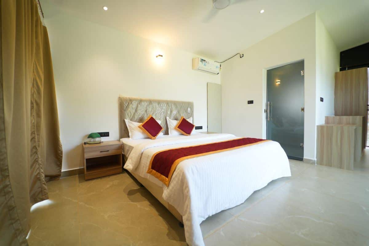 A hotel room with a bed, nightstand, and a wardrobe.