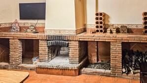 Una chimenea de ladrillo con chimenea, una mesa pequeña y una estructura decorativa de ladrillo con múltiples aberturas.
